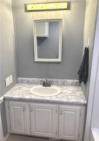 a bathroom with a granite countertop sink and a mirror