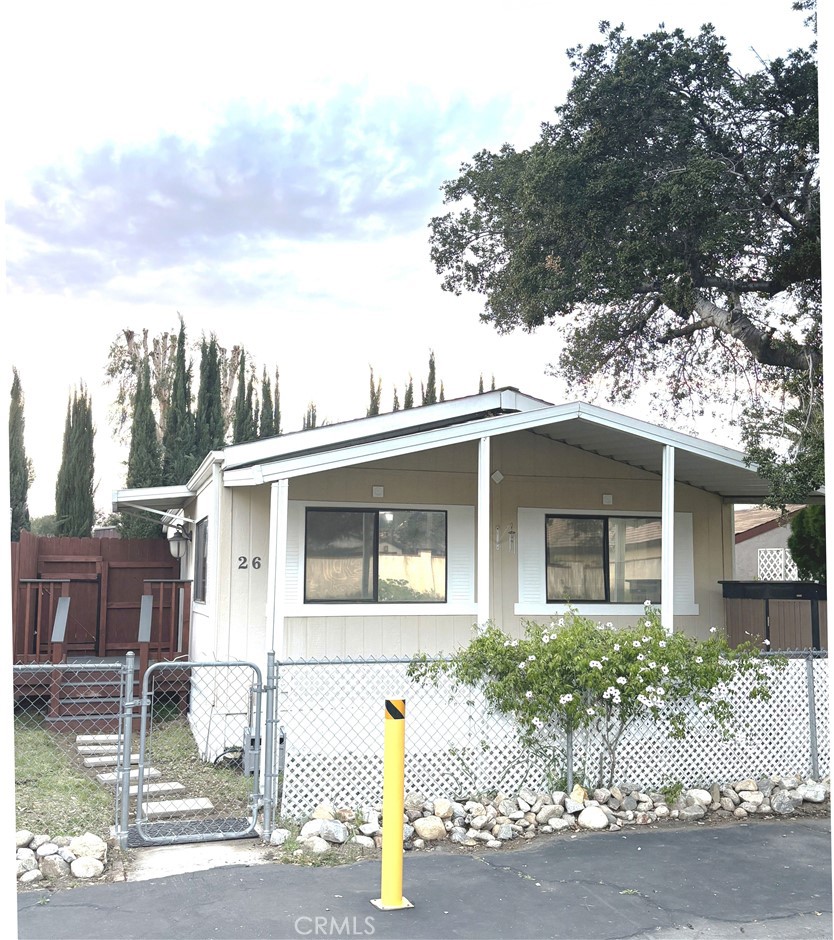 21515 Placerita Canyon Road, Unit 26 Newhall, CA 91321 - Photo 2 of 19 a front view of a house with a yard