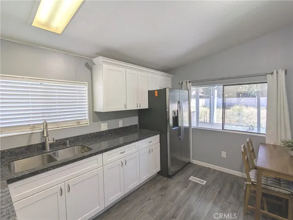 a kitchen with granite countertop white cabinets and white appliances