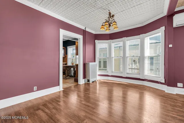 a kitchen with stainless steel appliances granite countertop a stove a refrigerator a sink and white cabinets with wooden floor