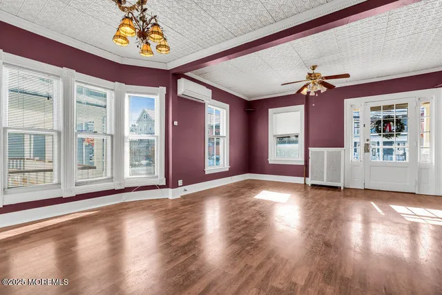 a view of a hallway with wooden floor and stairs