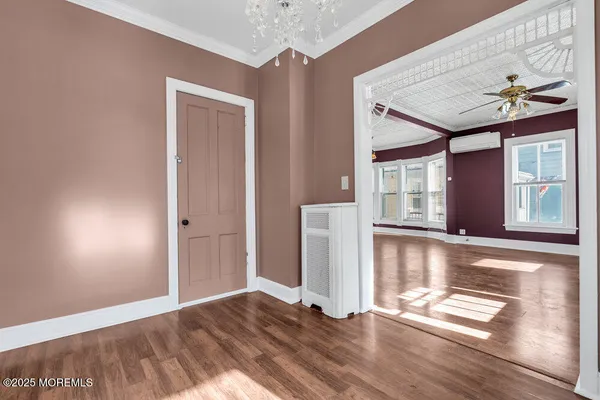 a view of empty room with wooden floor and fan