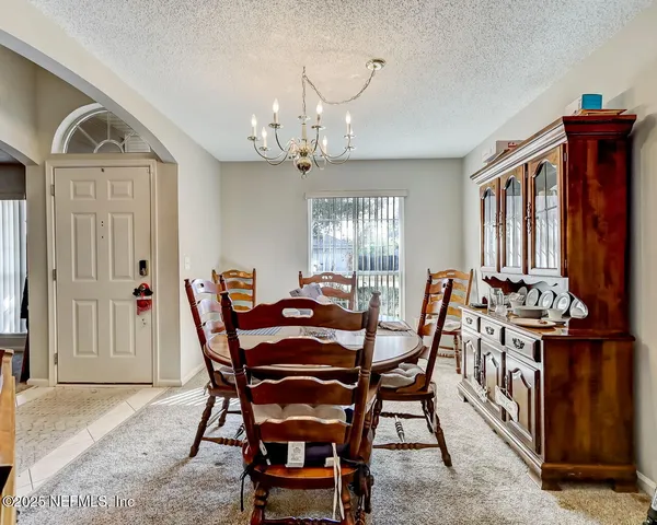 a view of a dining room with furniture and chandelier