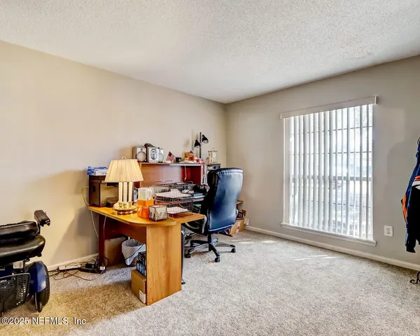 a view of a workspace with furniture and a window