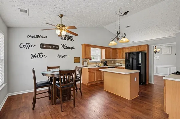 a kitchen with stainless steel appliances granite countertop a kitchen island a stove a table and chairs in it