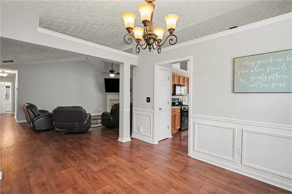 a view of a livingroom with furniture a chandelier wooden floor and a chandelier