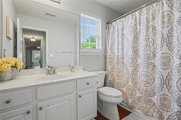 a bathroom with a granite countertop sink a toilet and a mirror