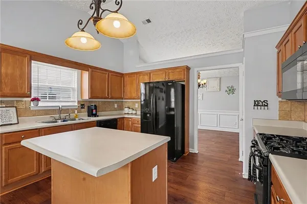 a kitchen with a refrigerator a stove a sink and a cabinets