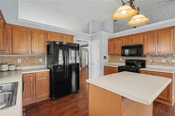 a kitchen with a refrigerator and a stove top oven