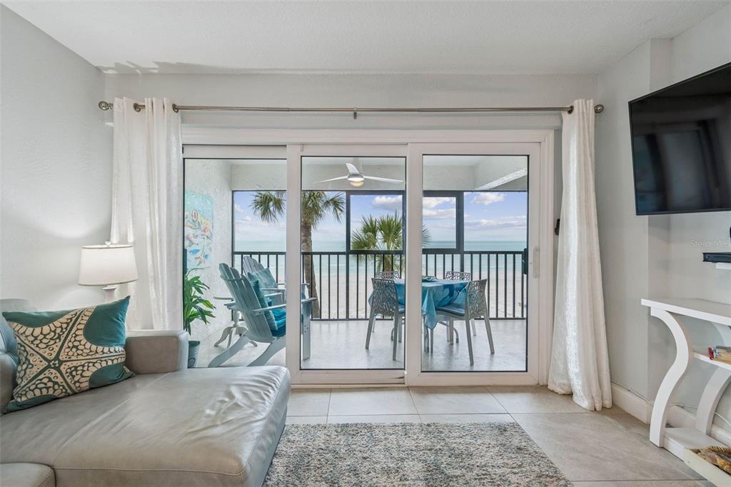 14600 Gulf Boulevard, Unit 102 Madeira Beach, FL 33708 - Photo 12 of 46 a living room with a large window and a potted plant