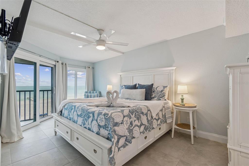14600 Gulf Boulevard, Unit 102 Madeira Beach, FL 33708 - Photo 13 of 46 a bedroom with a large bed and a chandelier