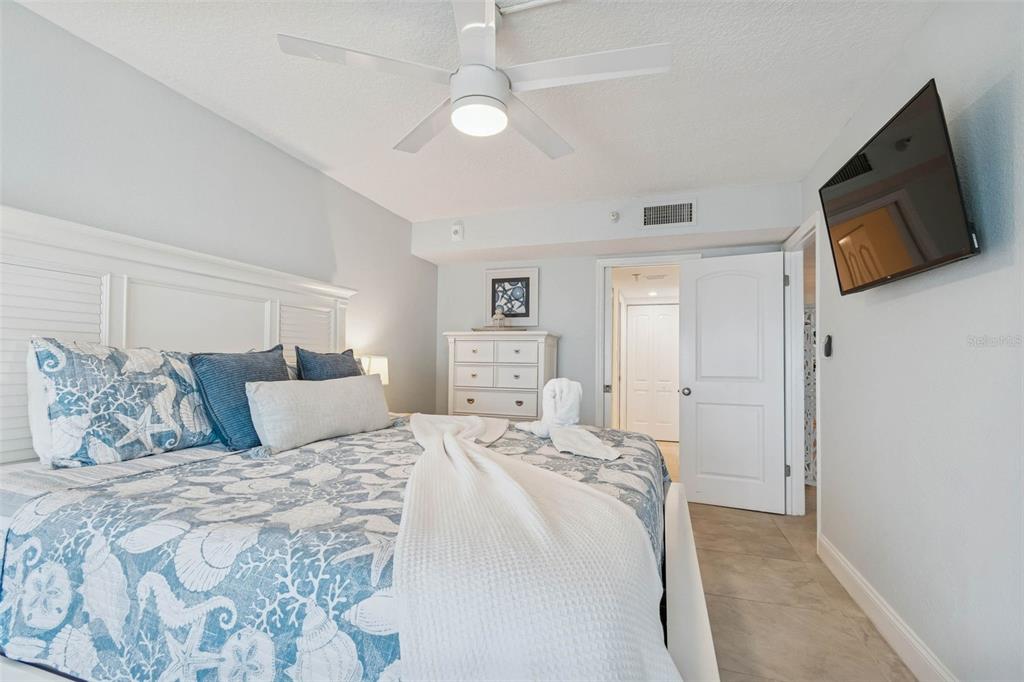 14600 Gulf Boulevard, Unit 102 Madeira Beach, FL 33708 - Photo 15 of 46 a large bedroom with a bed and a flat screen tv