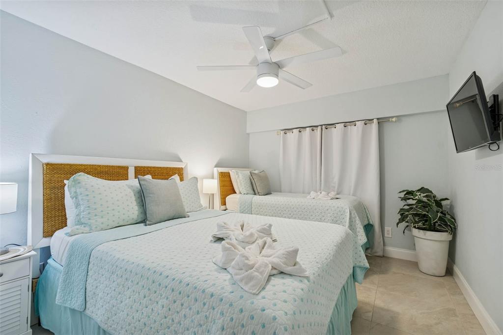 14600 Gulf Boulevard, Unit 102 Madeira Beach, FL 33708 - Photo 20 of 46 a bedroom with bed and ceiling fan