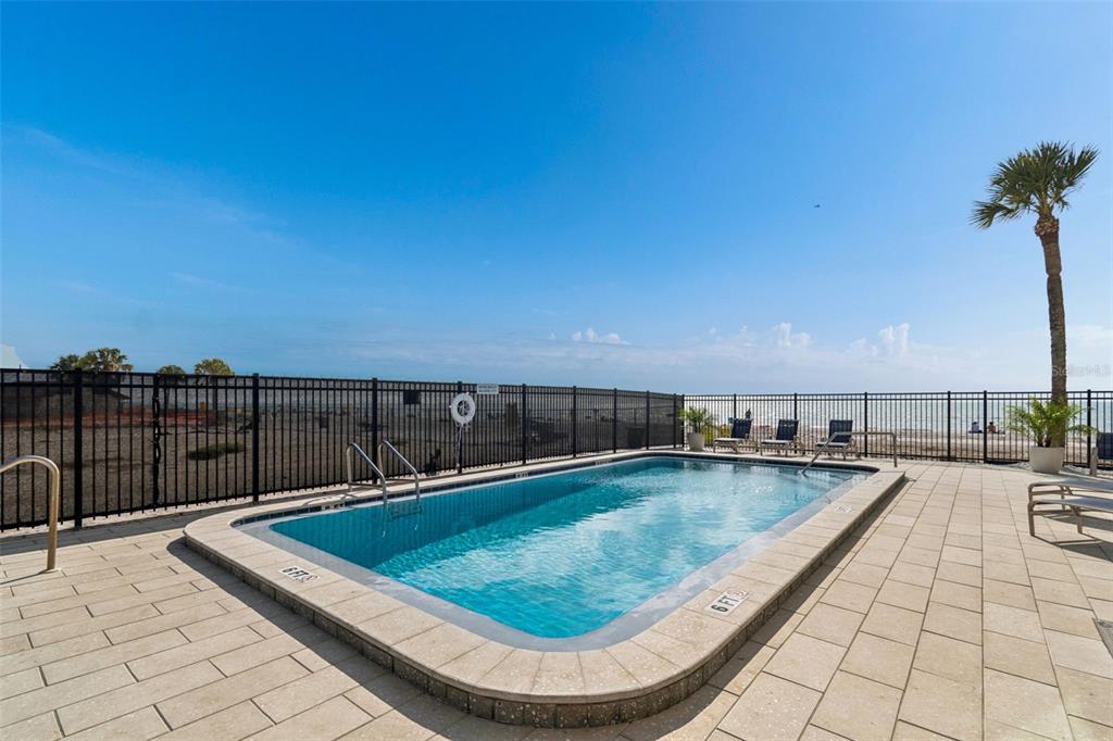 14600 Gulf Boulevard, Unit 102 Madeira Beach, FL 33708 - Photo 32 of 46 a view of a swimming pool with a lounge chair
