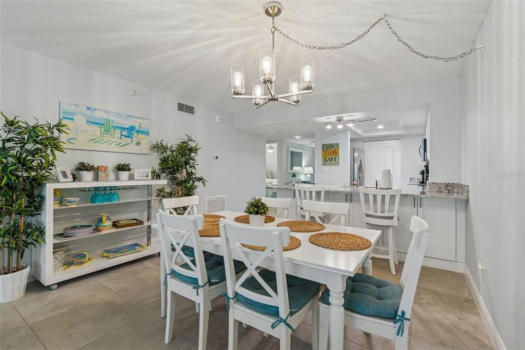 14600 Gulf Boulevard, Unit 102 Madeira Beach, FL 33708 - Photo 8 of 46 a view of a dining room with furniture and chandelier