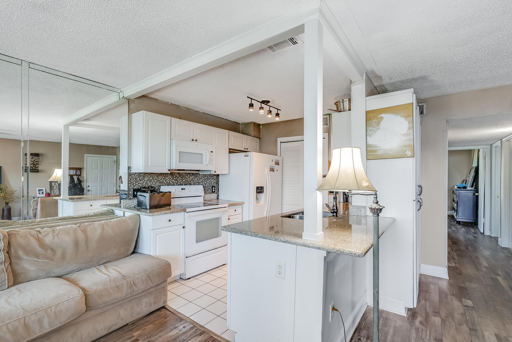 200 Pensacola Beach Road, Unit D2 Gulf Breeze, FL 32561 - Photo 13 of 38 a living room with stainless steel appliances furniture a rug and a kitchen view