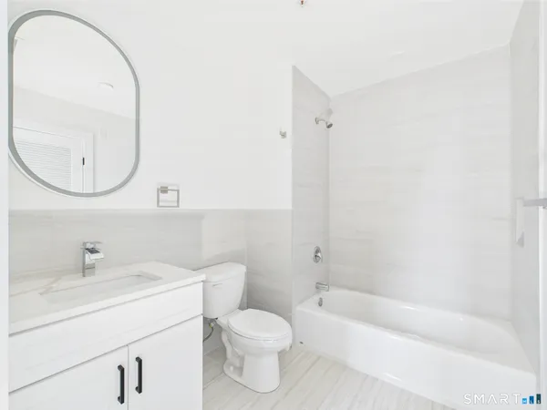 a bathroom with a sink a toilet and a mirror