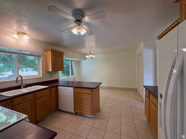 595 Meadowlark Road Orem, UT 84097 - Photo 21 of 87 Kitchen featuring wood cabinetry, a double basin sink with a gooseneck faucet, a white dishwasher, and tiled flooring