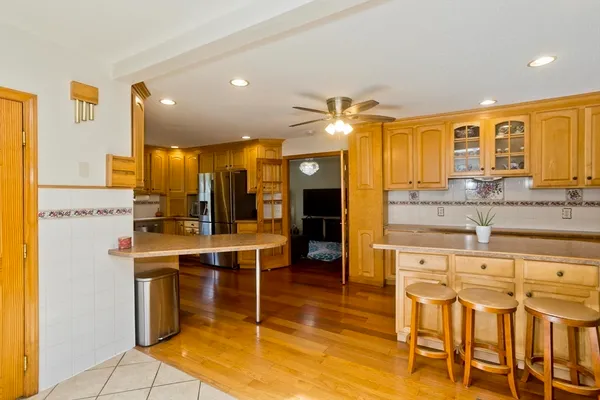 a view of a kitchen with kitchen island granite countertop wooden cabinets and stainless steel appliances