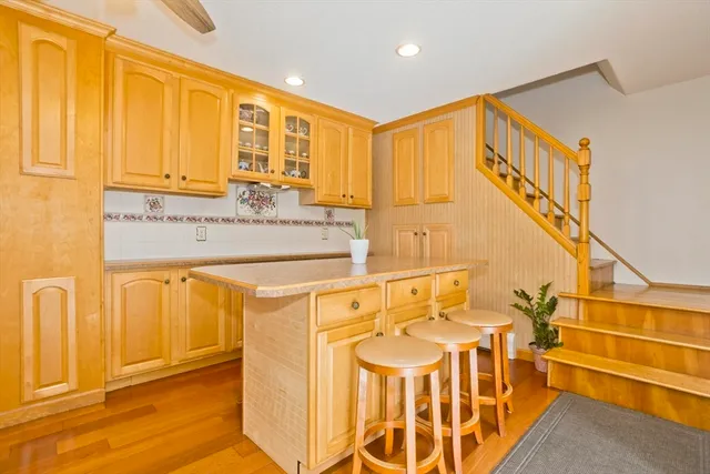 a kitchen with stainless steel appliances a stove a sink dishwasher and a microwave with wooden floor