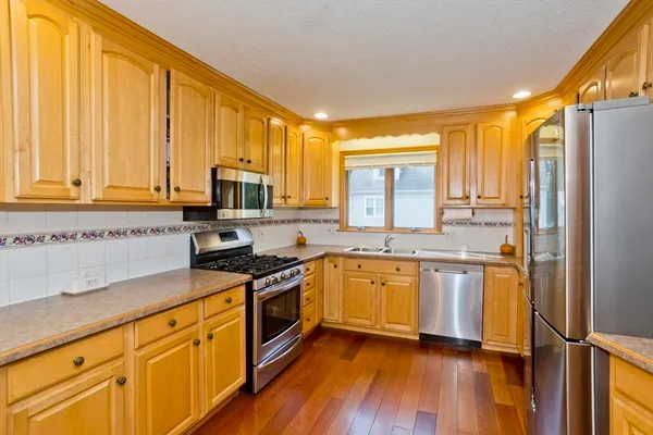 a kitchen with stainless steel appliances granite countertop a stove a sink and a refrigerator