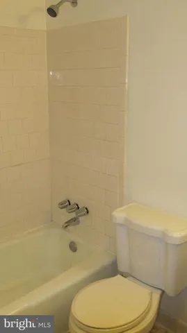 a white toilet sitting next to a bath tub and a shower