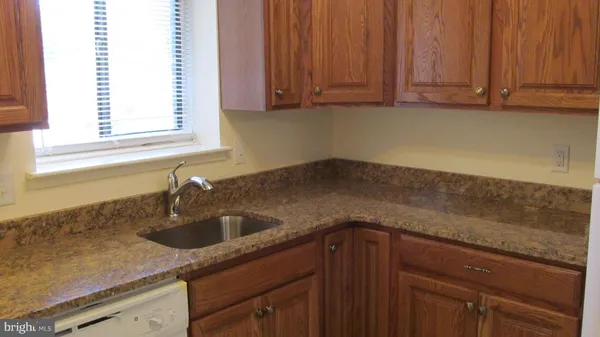 a kitchen with granite countertop a sink and cabinets