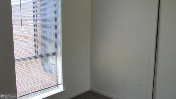a view of a small space with wooden floor and a window