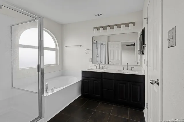 a bathroom with a bathtub sink vanity and mirror