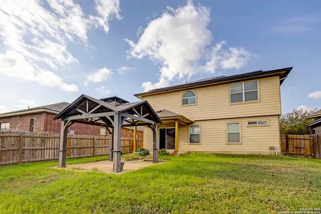 a view of a house with backyard and porch