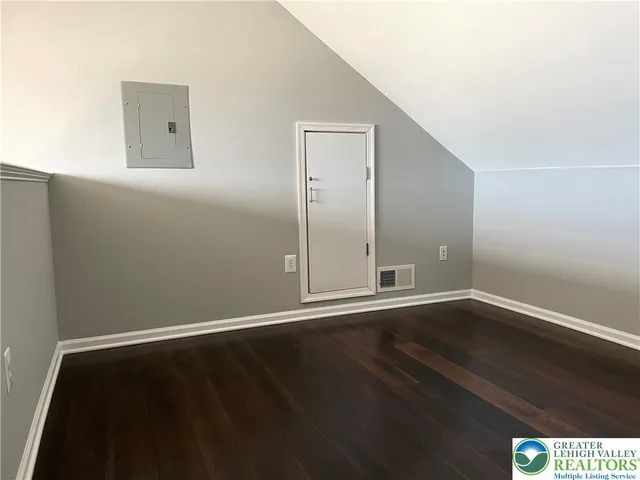 an empty room with wooden floor and door