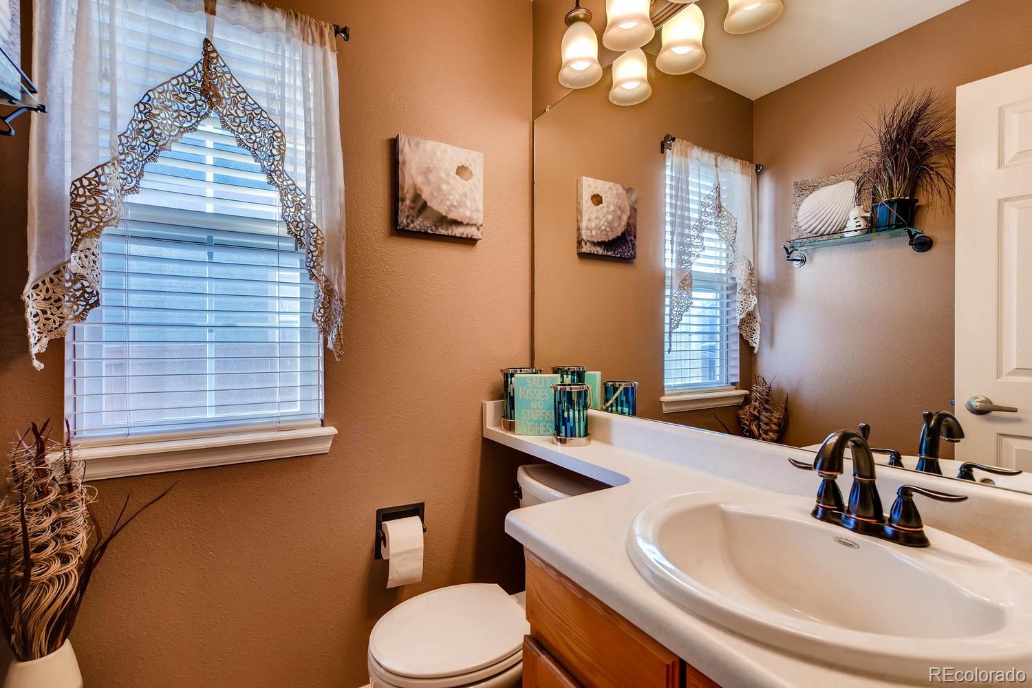9825 South Thornbury Way Highlands Ranch, CO 80129 - Photo 11 of 27 a bathroom with a sink and a mirror