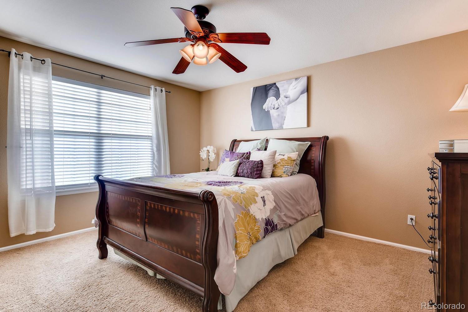 9825 South Thornbury Way Highlands Ranch, CO 80129 - Photo 12 of 27 a bed sitting in a bedroom next to a window