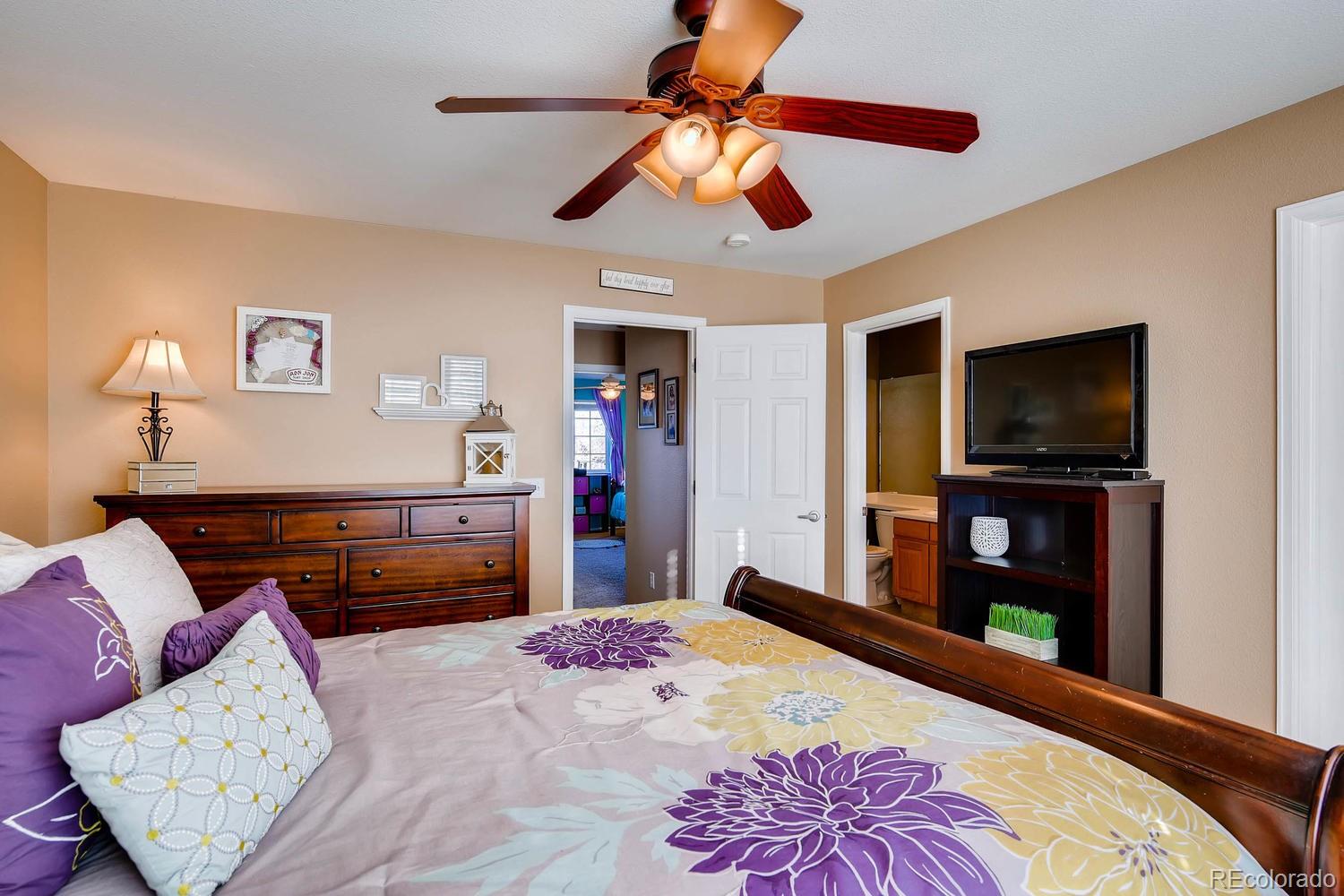 9825 South Thornbury Way Highlands Ranch, CO 80129 - Photo 13 of 27 a bedroom with a bed and a flat screen tv