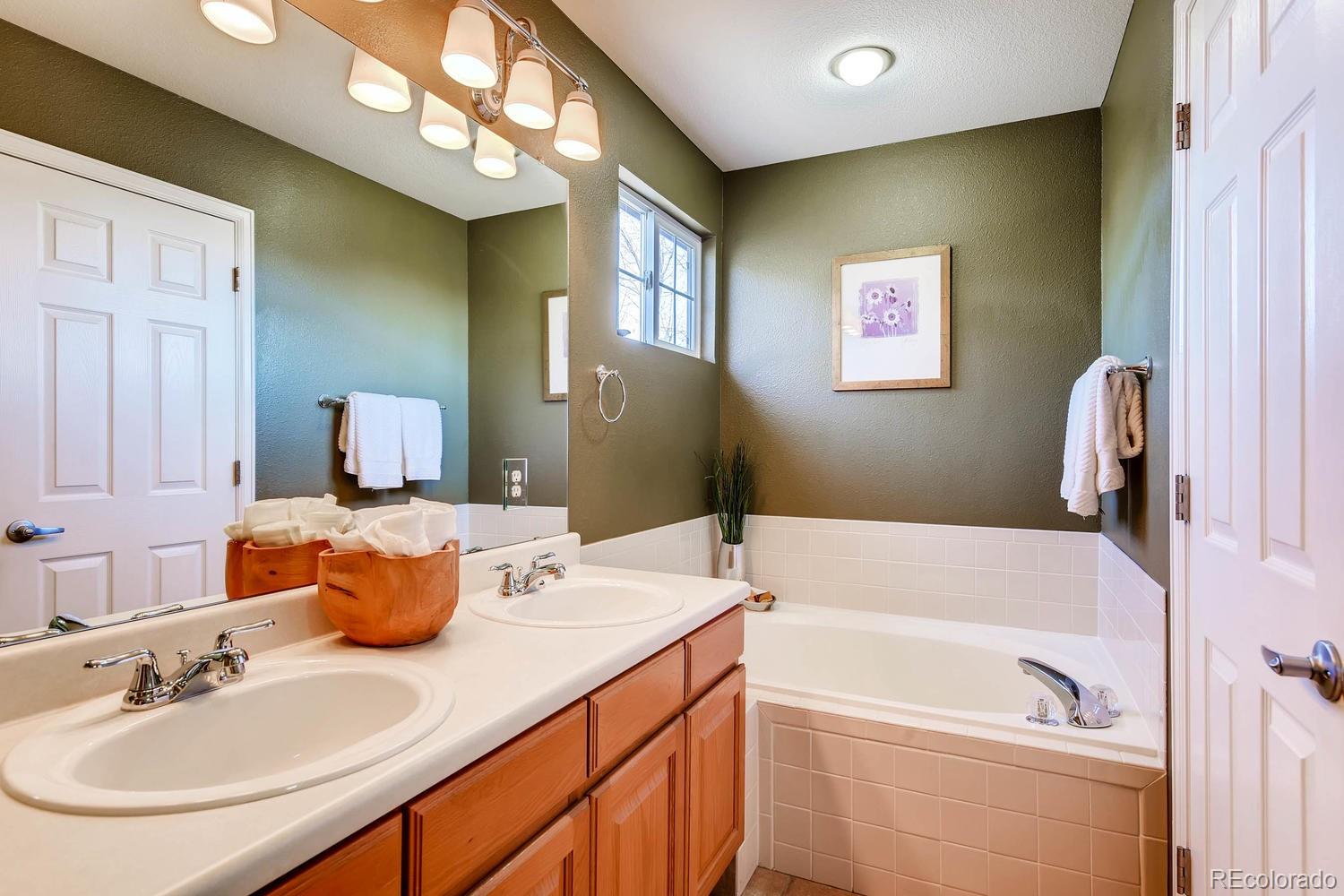 9825 South Thornbury Way Highlands Ranch, CO 80129 - Photo 14 of 27 a bathroom with a tub sink and mirror