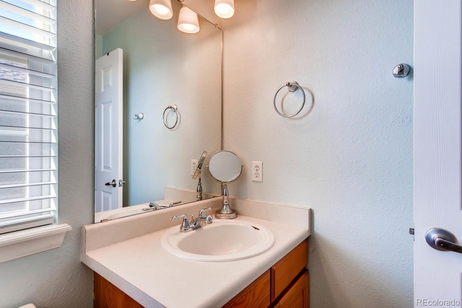 9825 South Thornbury Way Highlands Ranch, CO 80129 - Photo 18 of 27 a bathroom with a sink and a mirror