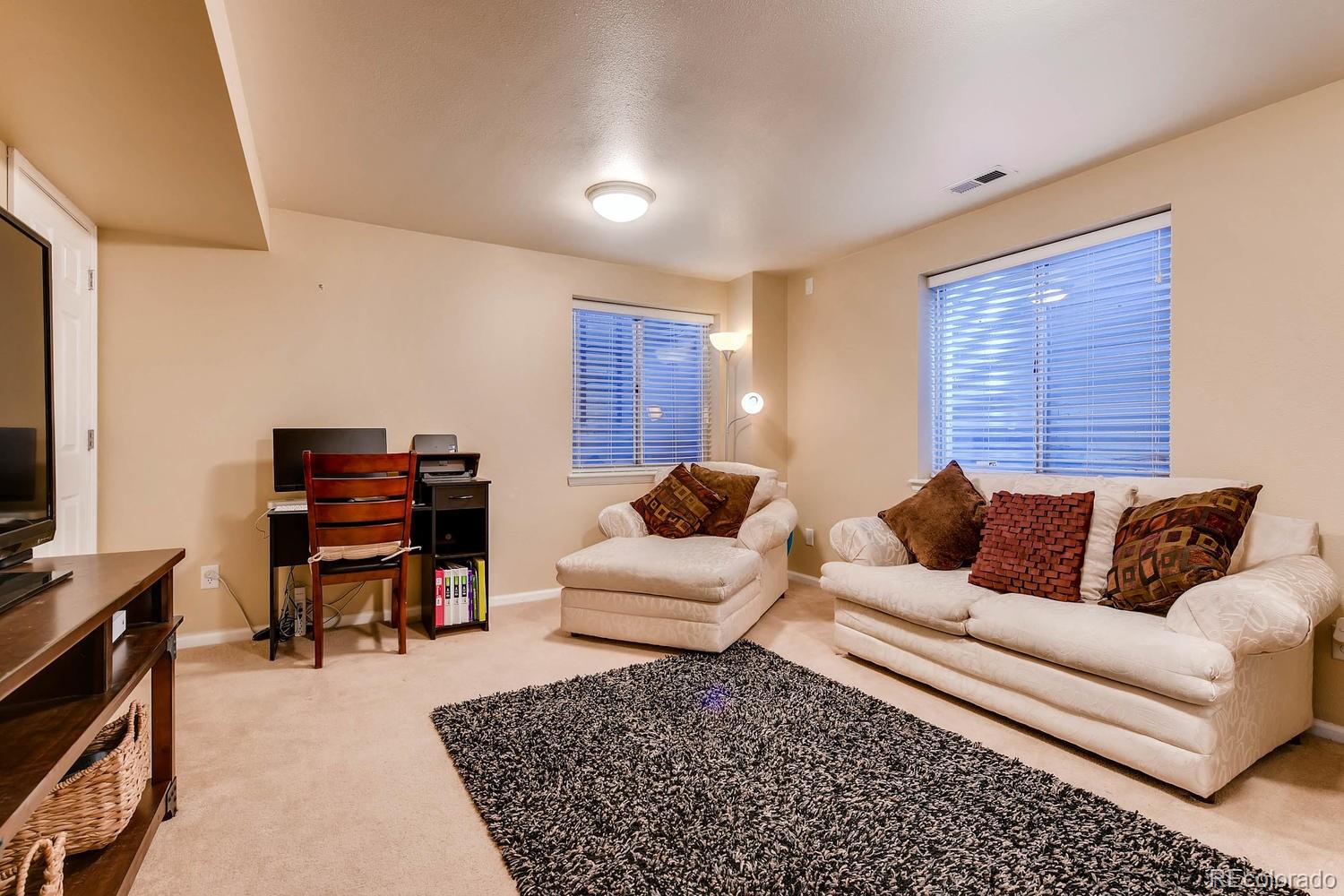 9825 South Thornbury Way Highlands Ranch, CO 80129 - Photo 20 of 27 a living room with furniture and a flat screen tv