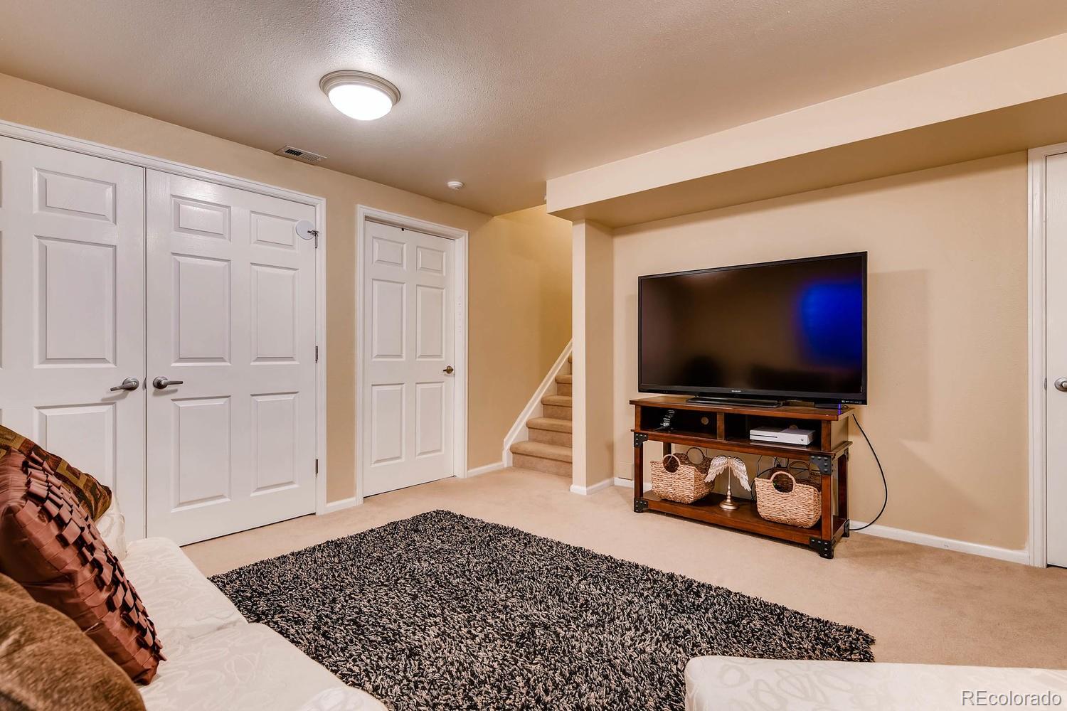 9825 South Thornbury Way Highlands Ranch, CO 80129 - Photo 21 of 27 a living room with furniture and a flat screen tv