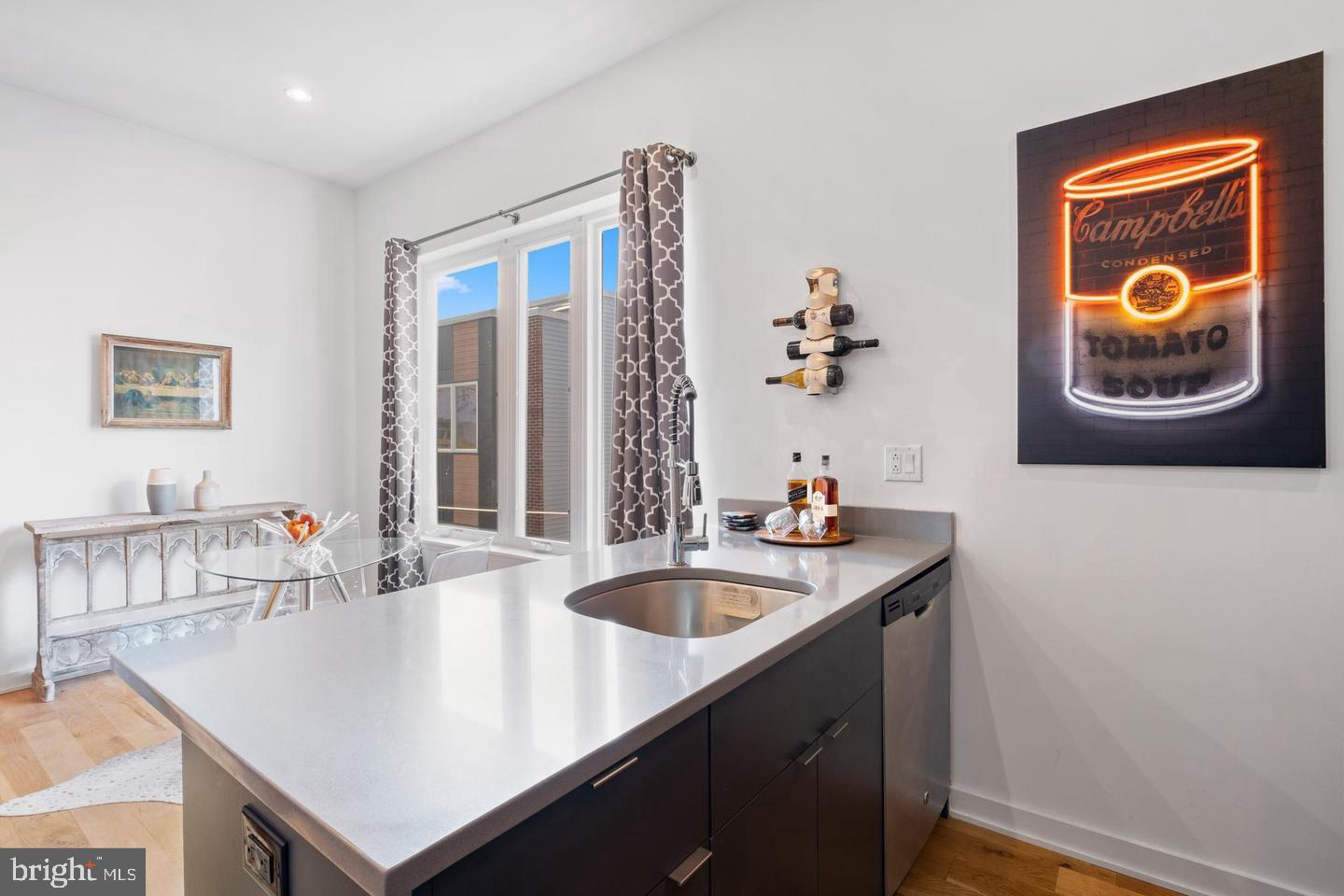 1617-27 Hope Street, Unit 2D Philadelphia, PA 19122 - Photo 11 of 32 a kitchen with a sink a counter and a chandelier