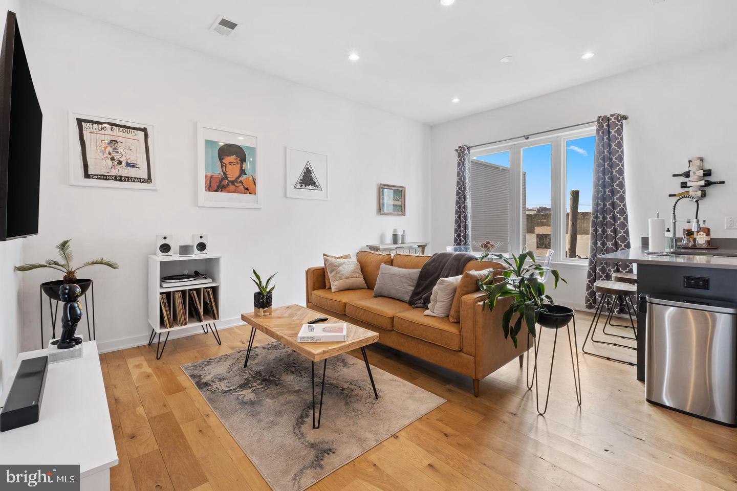 1617-27 Hope Street, Unit 2D Philadelphia, PA 19122 - Photo 2 of 32 a living room with furniture a wooden floor and a flat screen tv