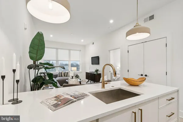 a view of kitchen with a sink stainless steel appliances and living room view