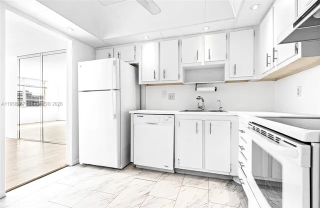 a kitchen with a white cabinets and white appliances