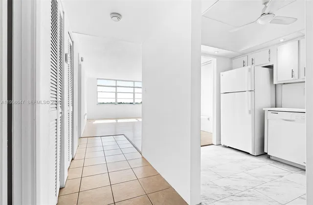 a view of a kitchen with a refrigerator and cabinets