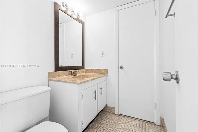a bathroom with a granite countertop sink a toilet and a mirror