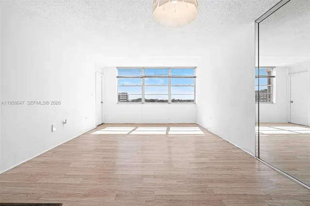 a view of empty room with wooden floor