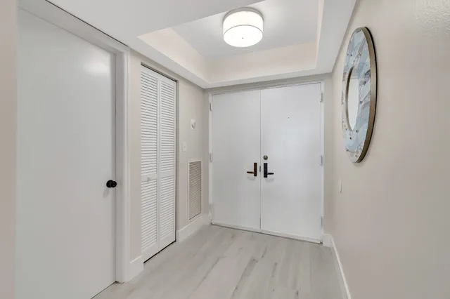 a large white kitchen with lots of counter space dining table and stainless steel appliances