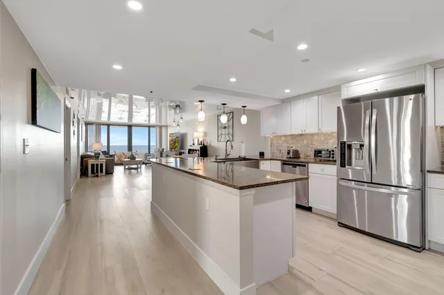a large white kitchen with cabinets and a sink
