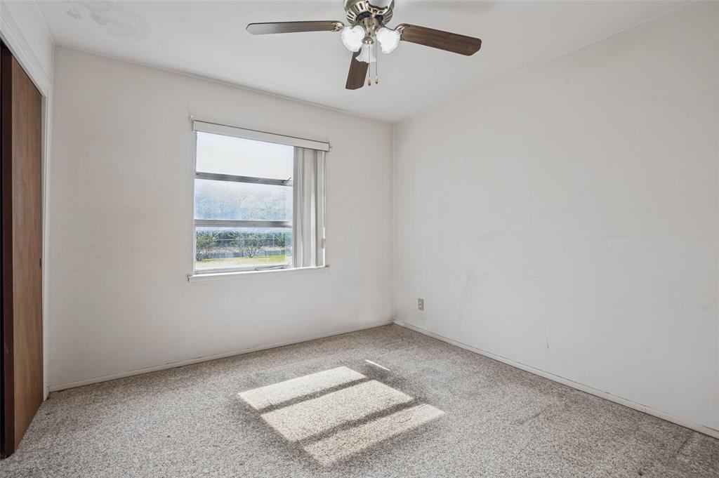 2528 Rugby Lane Farmers Branch, TX 75234 - Photo 5 of 12 Window with horizontal blinds, ceiling fan with light fixture, light-toned wall paint, and carpeted flooring