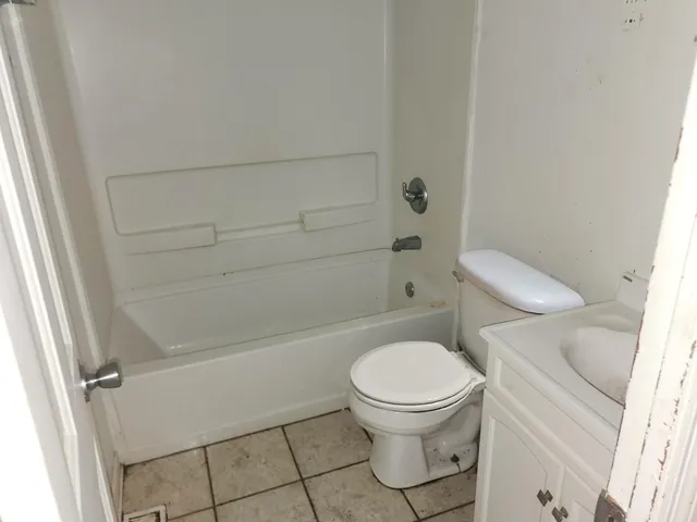 a white toilet sitting next to a bath tub