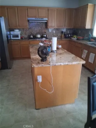 a kitchen with a refrigerator a stove a sink and cabinets